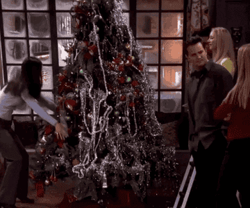 Friends cast with a Christmas tree