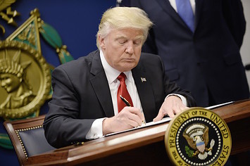U.S. President Donald Trump signs executive orders in the Hall of Heroes
