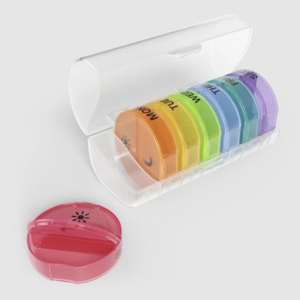 The pill organizer with different colored pop-out containers for each day of the week, each with two compartments for night (moon) and day (sun)