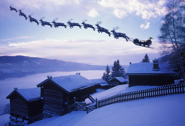 Santa and his reindeer flying up into the sky
