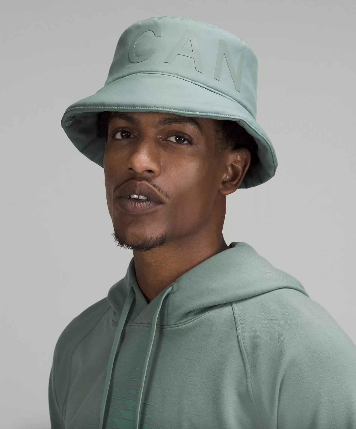 a person wearing the reversible insulated bucket hat with a matching sweatshirt