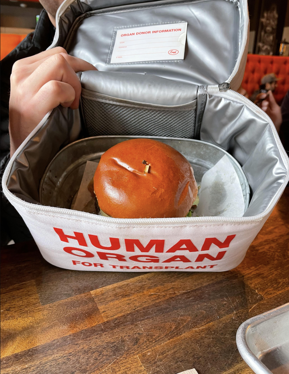 A burger served inside a bag that says &quot;human organ for transplant&quot;