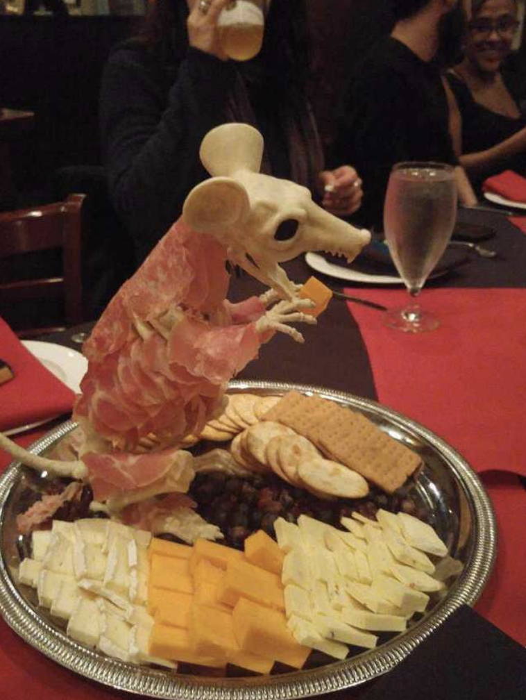 A cheese plate with the skeleton of a small animal in the middle