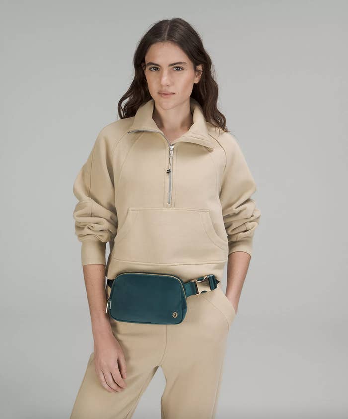a person wearing the velour belt bag around their waist with a neutral sweatsuit
