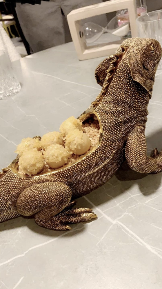 Small balls of food served inside a fake iguana that has had its back hollowed out to fit the food