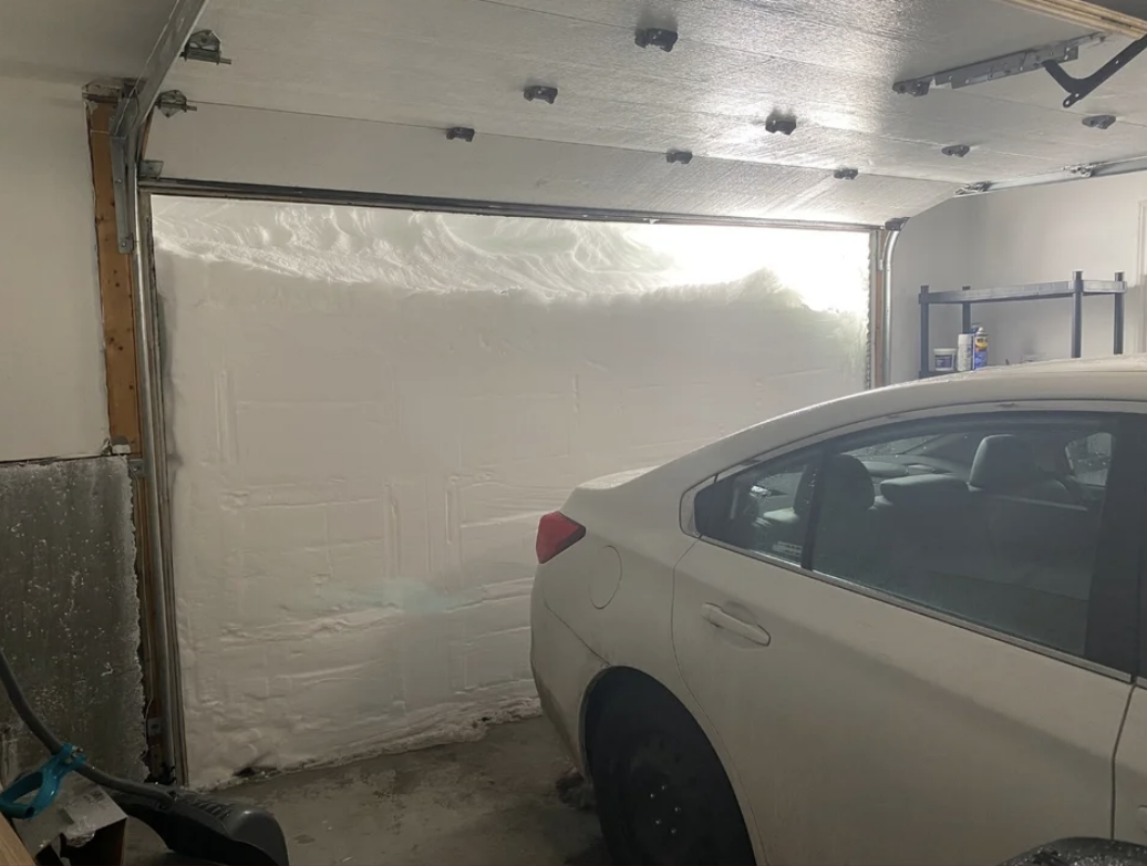 Open door seen from inside the garage shows snow up to the top