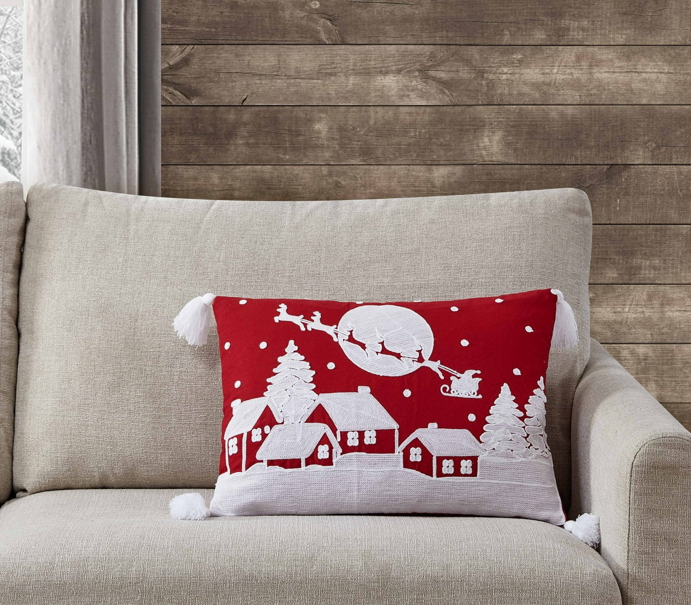 the red pillow with white houses and santa's sleigh on it