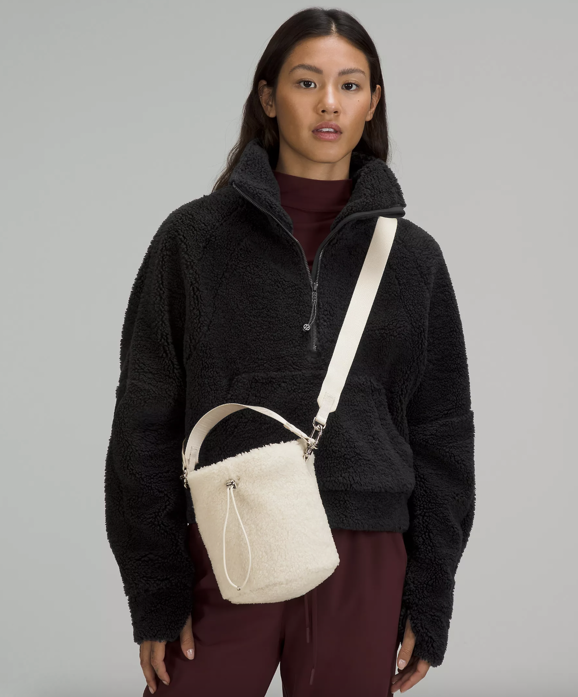 a person wearing the fleece bucket bag with a sherpa sweatshirt