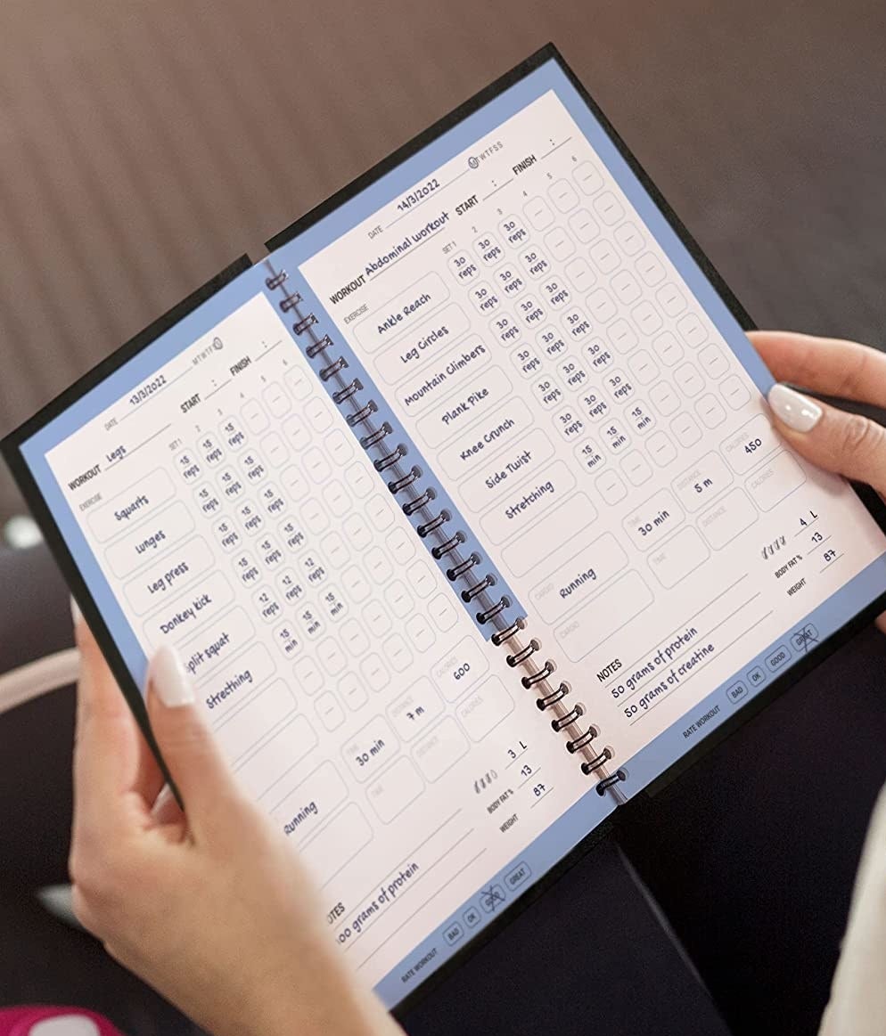 a person holding the fitness journal open in their hands