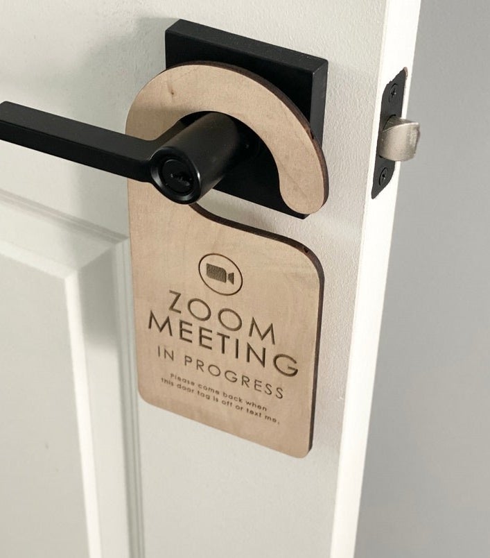 a wooden door sign that reads &quot;Zoom meeting in progress. Please come back when this door tag is off or text me&quot;