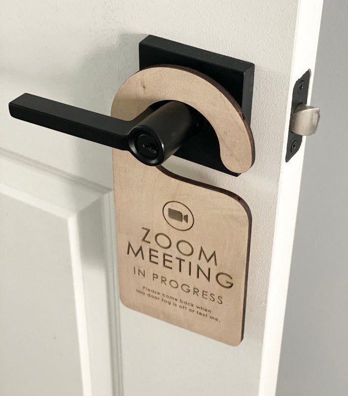 a wooden door sign that reads &quot;Zoom meeting in progress. Please come back when this door tag is off or text me&quot;