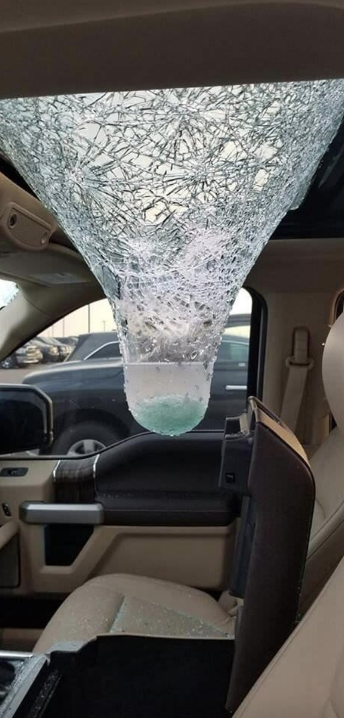 Shattered car sunroof with a huge icicle hanging from it