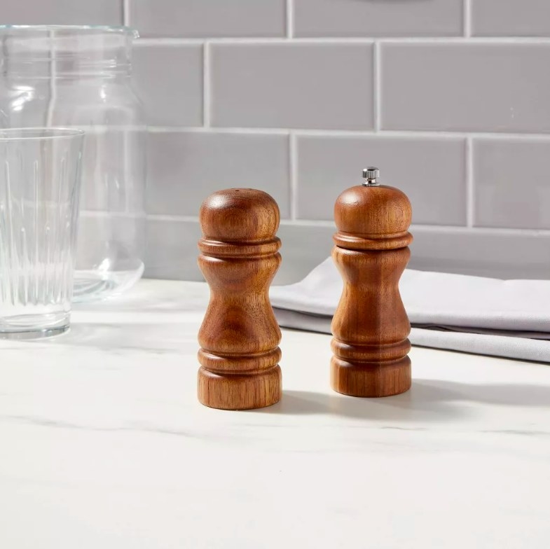 Wood salt shaker and pepper grinder on a kitchen countertop
