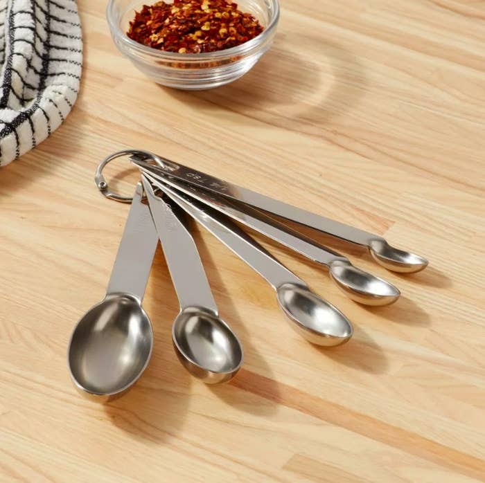 Stainless steel measuring spoon on a wood countertop