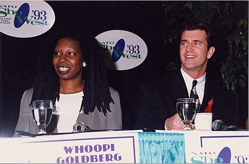Whoopi and Mel smiling and sitting together on a panel