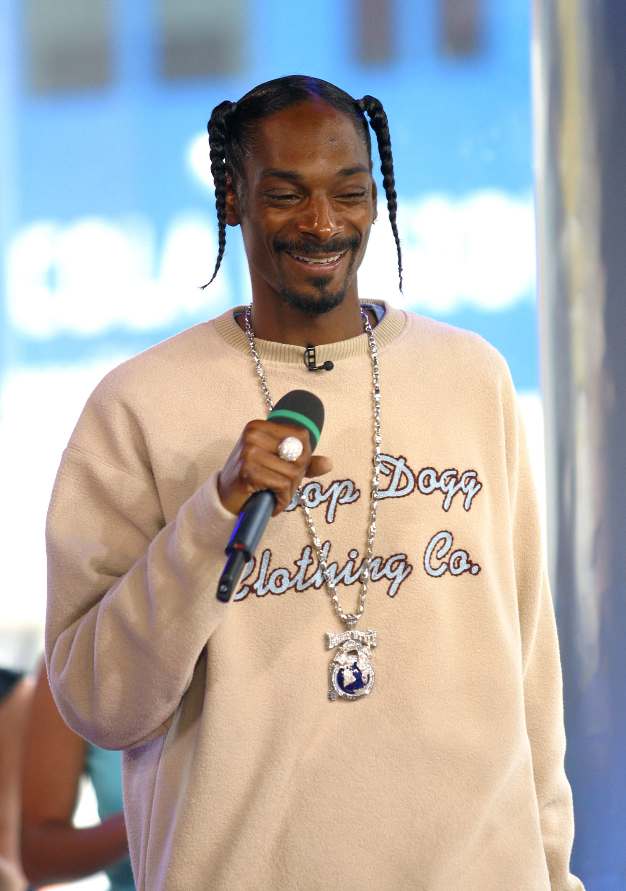 Snoop smiling with a mic