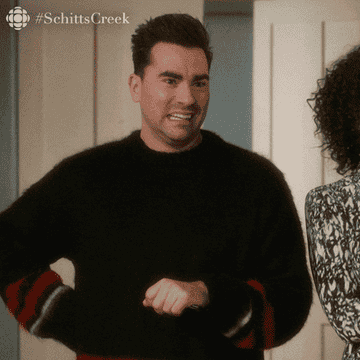 a gif of dan levy clapping his hands and saying very impressed