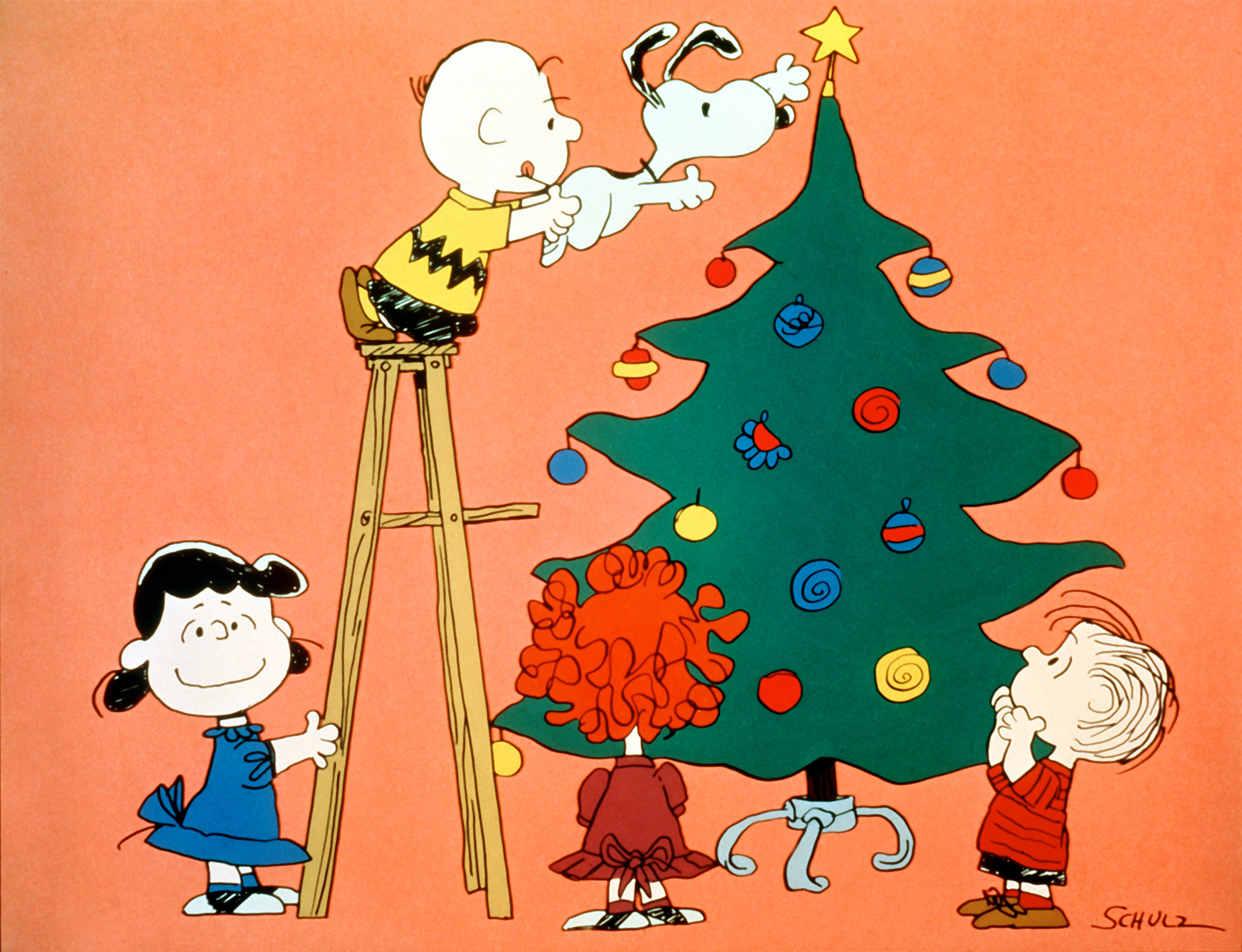 Snoopy putting a star on a Christmas tree with other friends helping
