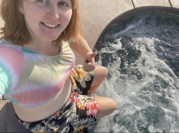 the author smiling and soaking her feet in water