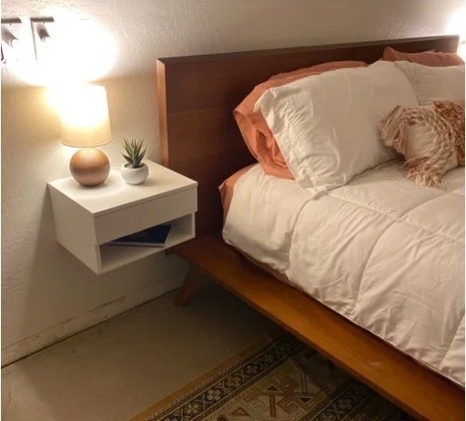 The nightstand in white next to a bed