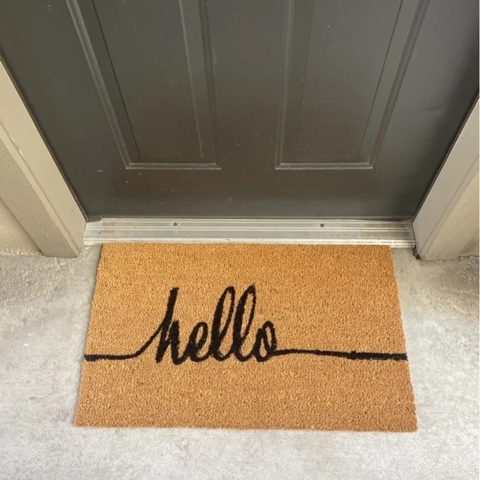 The door mat reading &quot;hello&quot; in front of the front door 