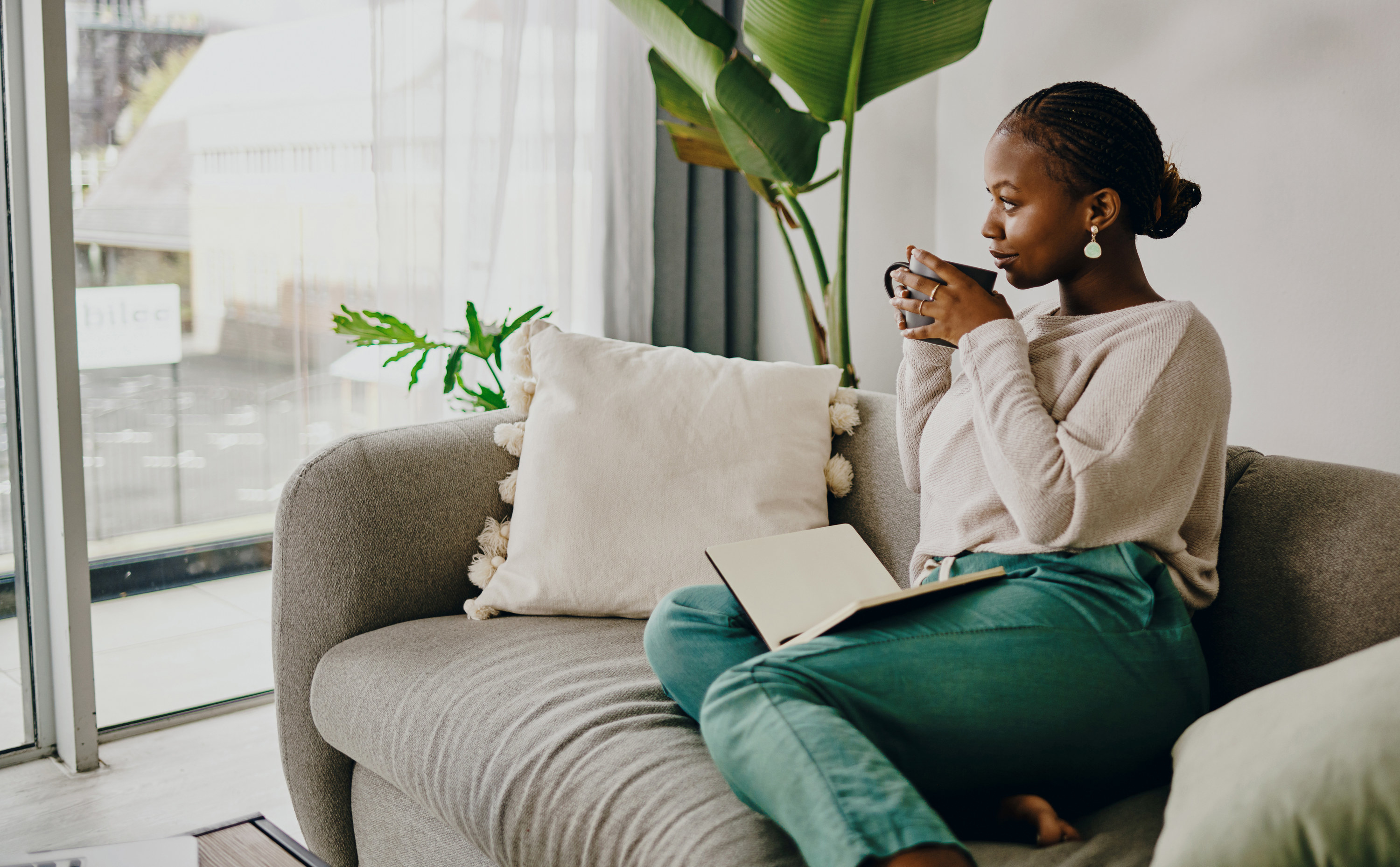 a woman drinking coffee with a journal