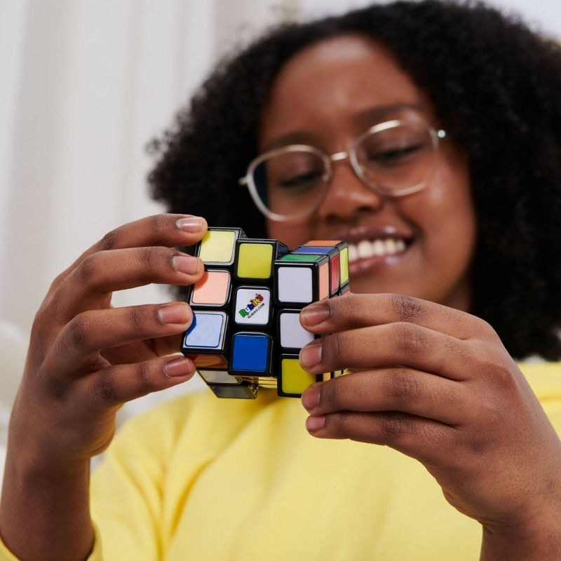 child playing with colorful Rubik&#x27;s Cube