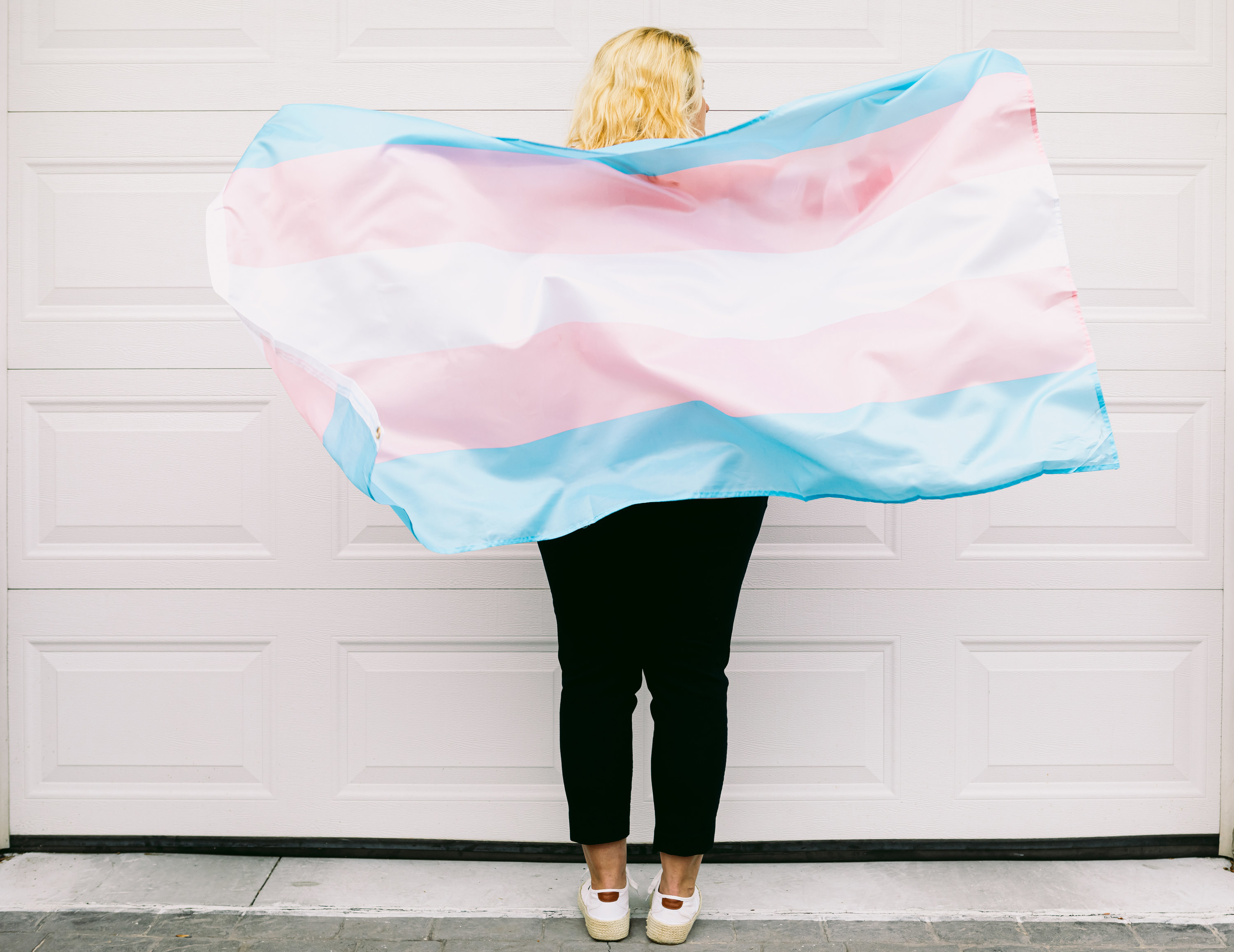a person holding a transgender flag