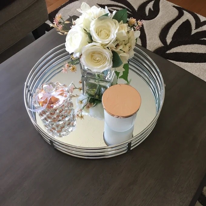 The tray on display holding a candle and flowers