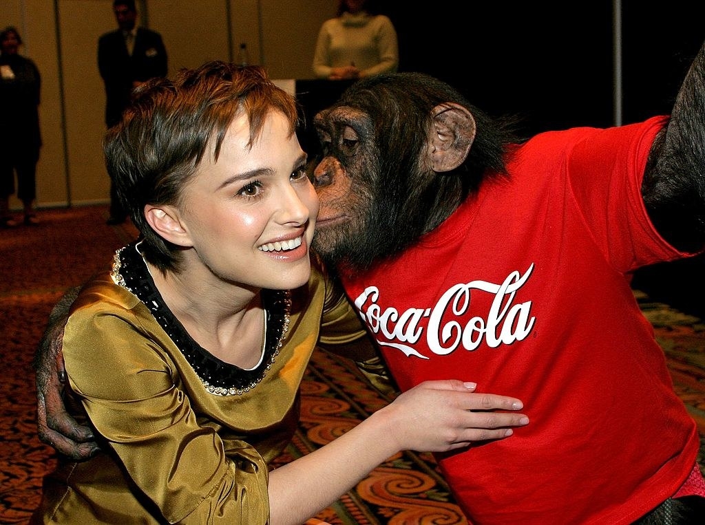 Natalie being embraced by a monkey wearing a Coca-Cola T-shirt