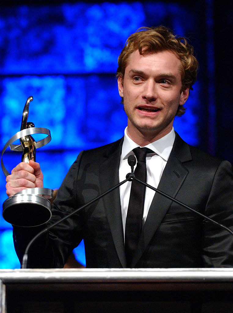 Jude at a podium holding an award