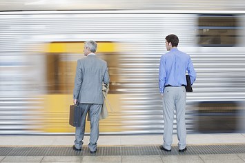 Two men waiting for train on platform.