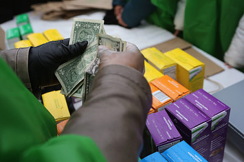 Money is collected as Girl Scouts sell cookies.