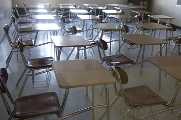 Empty chairs and desks in a high school classroom.