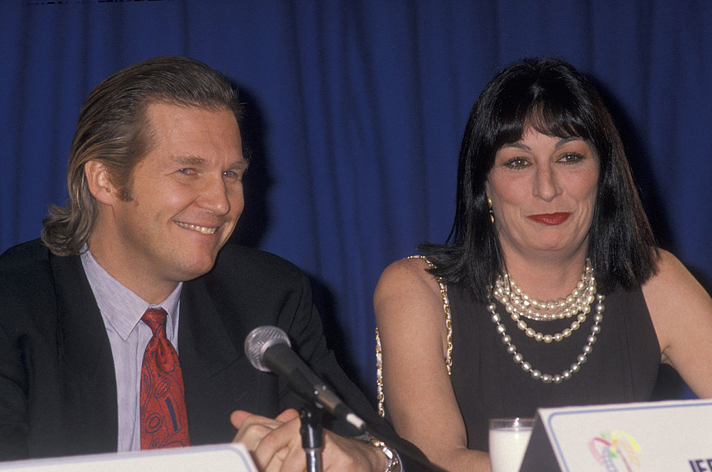 Jeff and Anjelica sitting together in front of a microphone