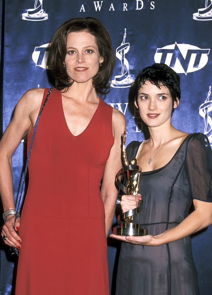 Winona standing with Sigourney and holding an award