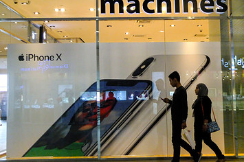 A couple is seen passing by the Apple Machine store at Kuala Lumpur