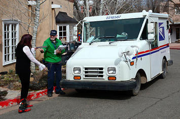 A USPS mailman delivering the mail.