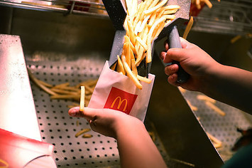 A  McDonald's crew member preparing fries.