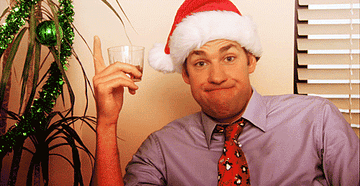 Man wearing a Santa hat and drinking from a cup