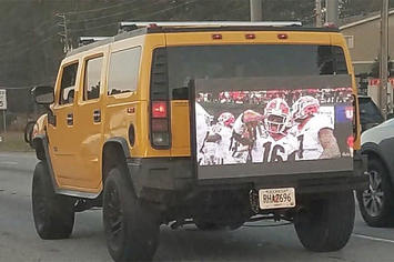 A cocky Georgia fan plays the SEC Championship Game on the back of his Hummer.