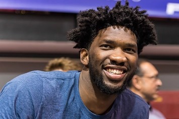 Joel Embiid laughs during a press conference.
