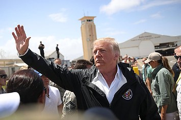 Donald Trump waves as he arrives at the Muniz Air National Guard base