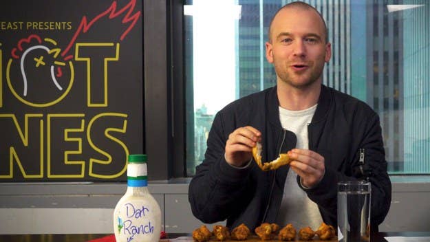 Hot Ones host Sean Evans learns how to properly eat a chicken wing.