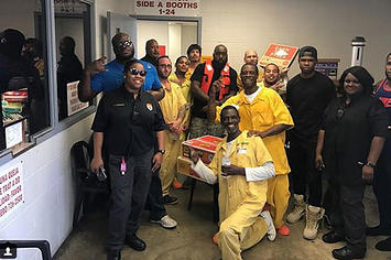 Trae Tha Truth poses with inmates and staff at a Texas jail.