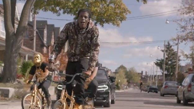 The BKRSCLB founder links up with Toronto’s one true grime emcee for a video featuring golden apes, BMX bikes, and a jewelry store heist. 