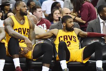 LeBron James and Kyrie Irving sit on the bench during a 2017 game.