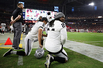Marshawn Lynch Giorgio Tavecchio of the Oakland Raiders kneel on the sidelines