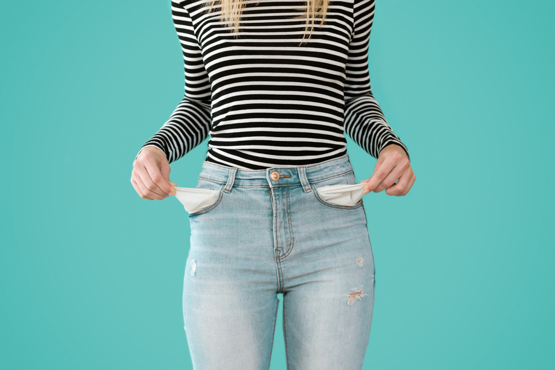 a woman pulling out her pockets from her jeans
