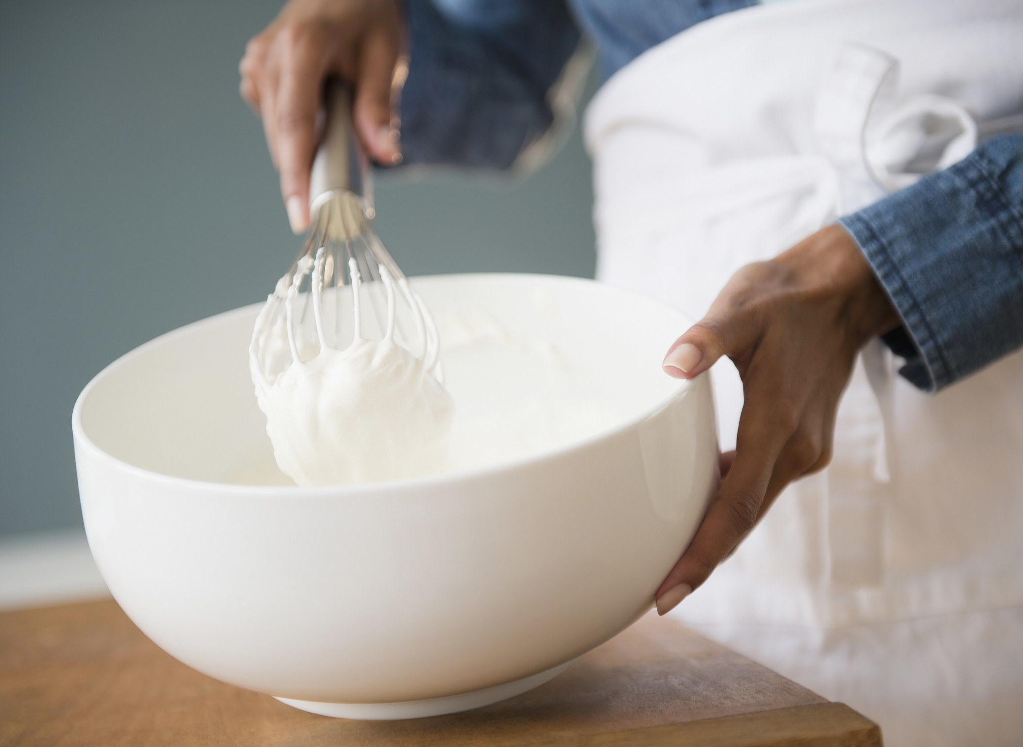 Person whipping heavy cream in bowl